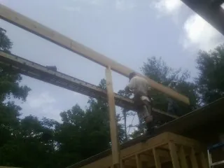 Carpenter setting a ridge beam over a new addition frame — Ice Dam Removal by Roofing Brothers in Raritan