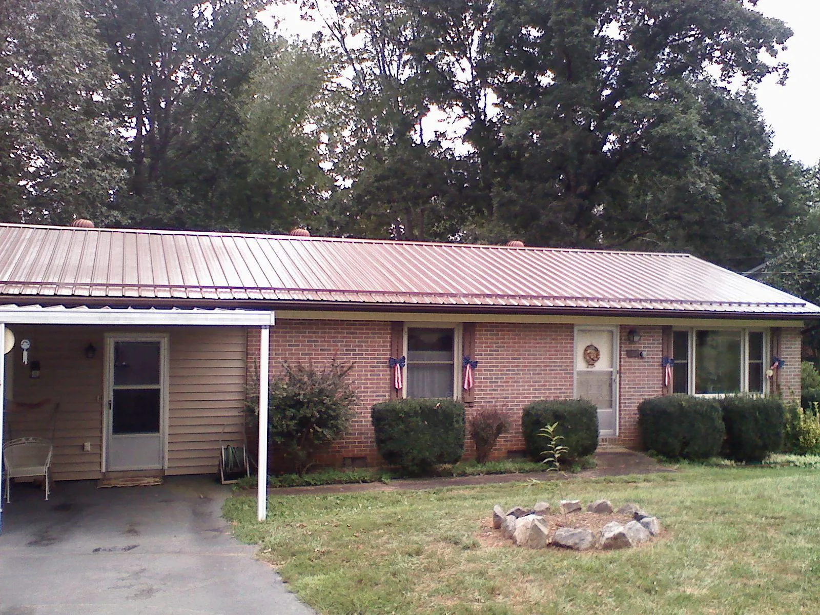 Bronze metal roof and carport on a brick ranch home — Roof Repair work by our crew in Raritan
